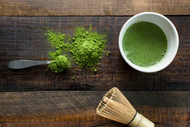 green plant in white ceramic mug beside brown wooden brush