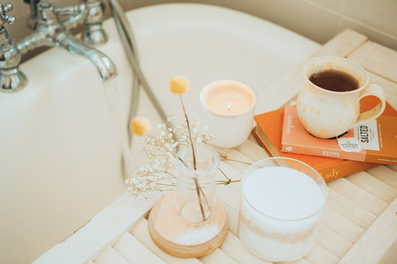 Photo by Maddi Bazzocco a cup of coffee and some books on a bathtub